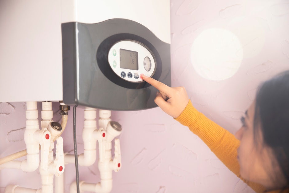 A woman setting an automated heating system