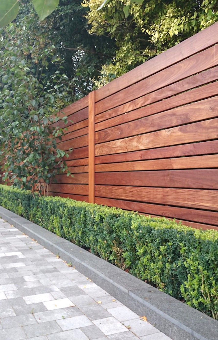 Make your tall fence less imposing with horizontal planks. Source: The Creativity Exchange