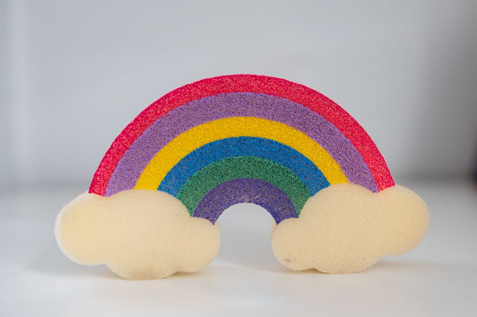 Rainbow-shaped decoration between two clouds, with a blurred gray background