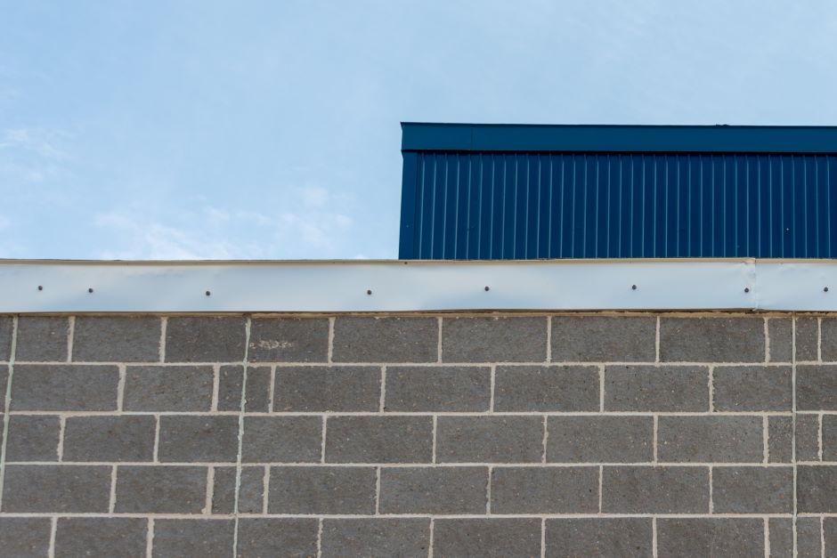 Image of a wall showing the flat roof flashing system.