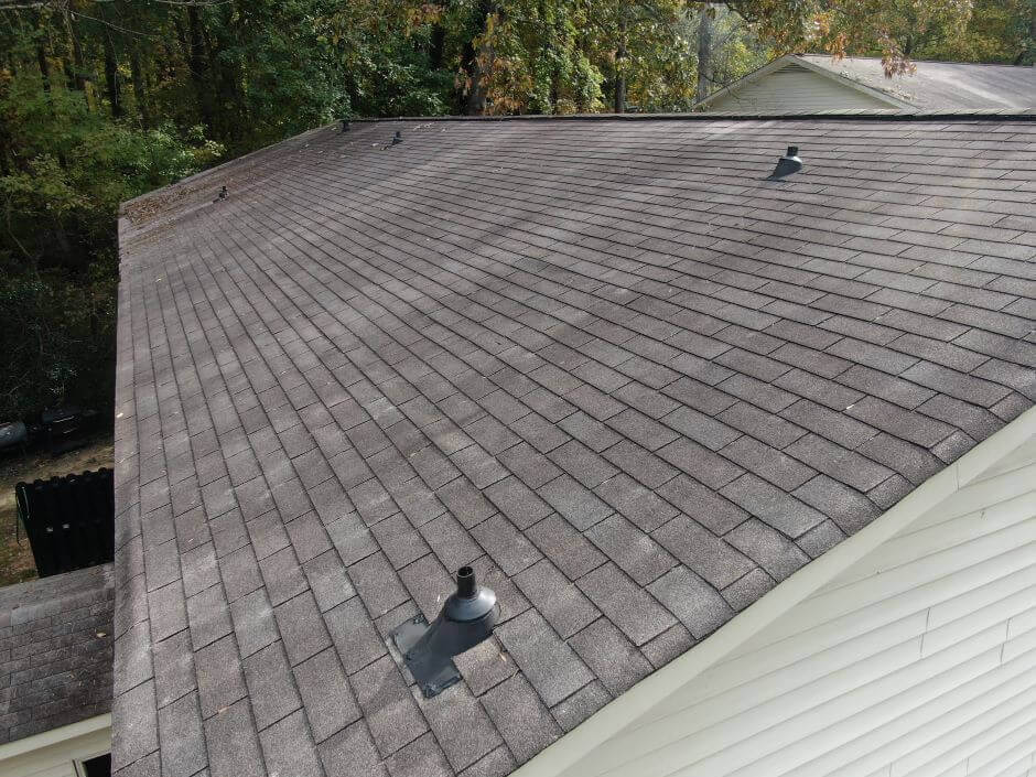 Image showing an asphalt shingle roof. In the backyard there are trees.