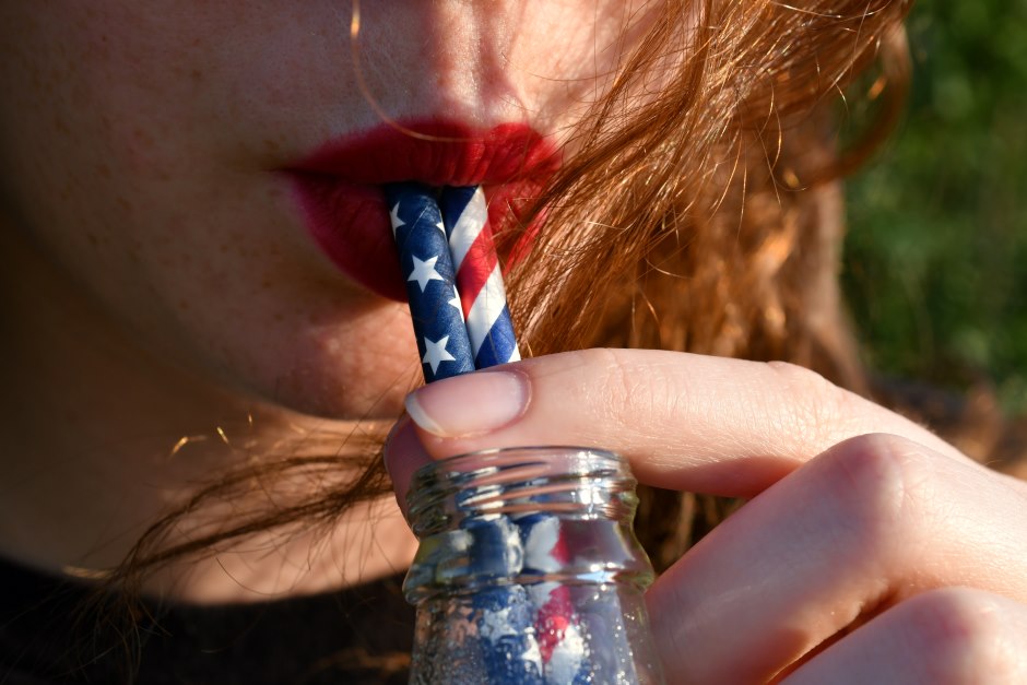 Female drinking in a bottle with straws personalized with the american flag