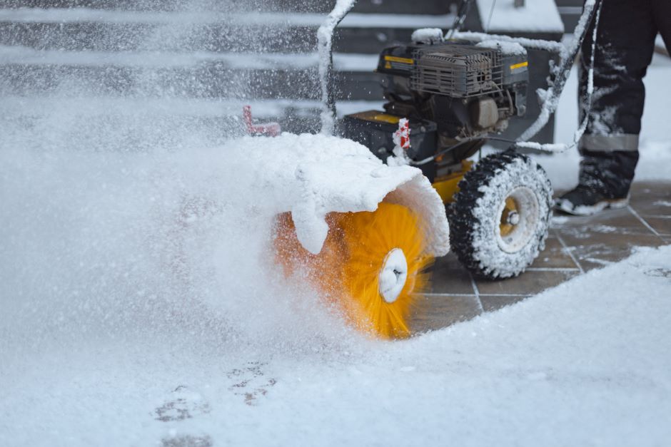 Motorized tool removing snow from the sidewalk