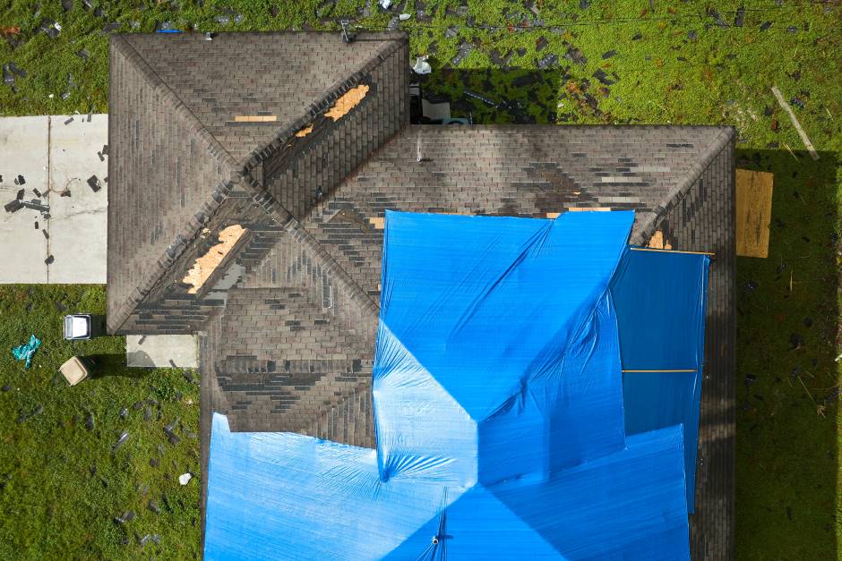 Roof seen from above. Some spaces without tiles and a part covered with a tarp