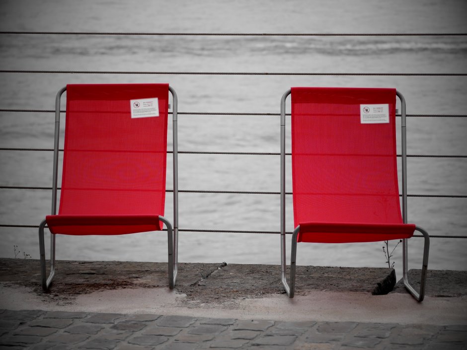 Two red comfortable chairs on a gray sidewalk