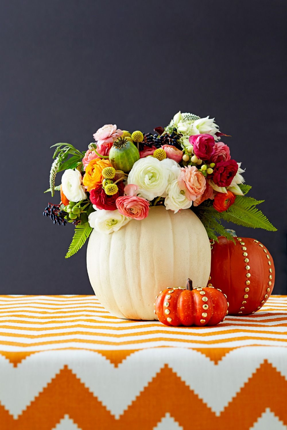 Turn pumpkins into vases for your centerpiece. Source: Good Housekeeping