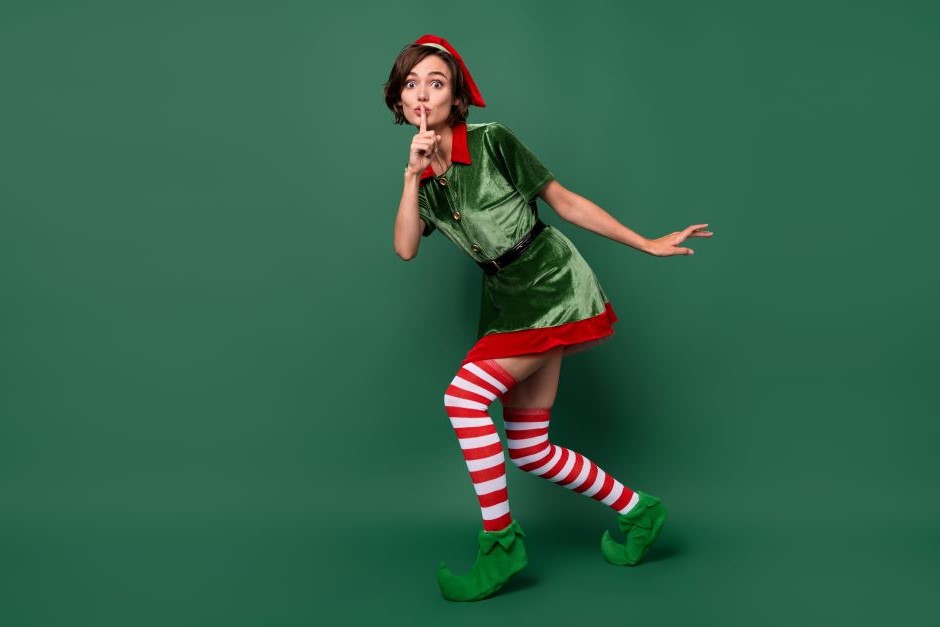 Full length body size view of mysterious funny girl elf showing shh sign isolated over green color background