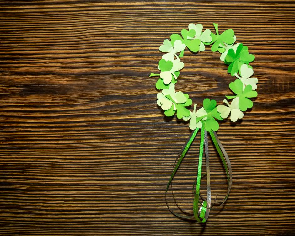 Paper wreath of st. patrick's day clover leaves on a brown wooden background